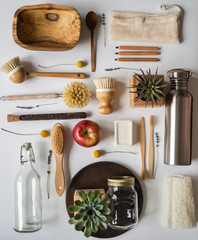 Zero waste concept. Flat lay eco-friendly set. Brushes, spoons, soap, bags, bottles and jar, spices in glass tubes on grey background. Top view