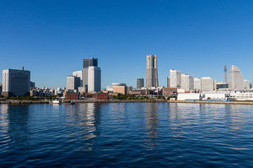 Obraz premium 富士山の初冠雪と横浜みなとみらいのビル群（撮影場所：横浜港大さん橋）