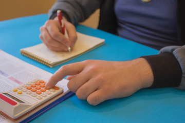 Close up view of bookkeeper or financial inspector hands making report, calculating or checking balance