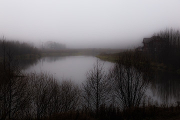 dense fog rises above the forest lake