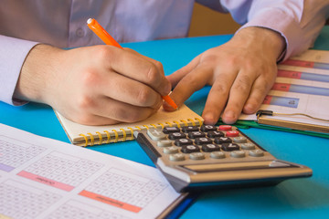 Businessman using a calculator to calculate the numbers. Businessman calculate finance and thinking about problem in office