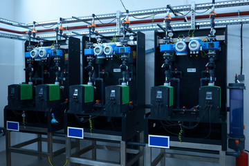 Dosing pumps, tubes, manometers set in the dosing systems hall of the water pumping station - obrazy, fototapety, plakaty