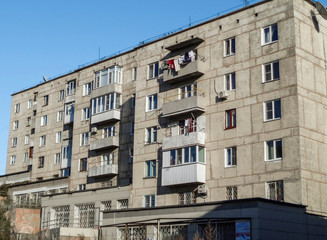 Fototapeta premium Soviet architecture. Ust-Kamenogorsk (Kazakhstan). Apartment building. Soviet architectural style. Typical socialist apartment building. Apartment block. Blue sky