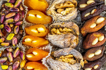 Sweet natural turkish delight background with dried apricots, figs, walnuts, pistachios and almonds.