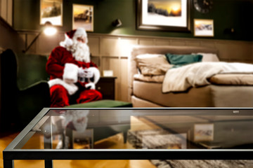 Coffee glass table of free space and red old santa claus in home interior. 
