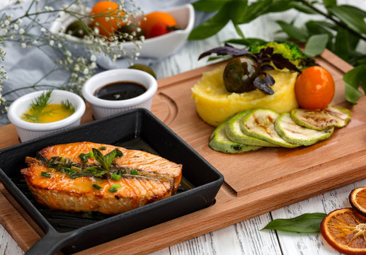roasted salmon steak in cast iron pan served with mashed potato