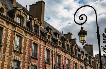 Obraz premium Close up on old buildings and street lamps of Place des Vosges during Autumn in Paris,The Place des Vosges the oldest planned square in Paris, France.