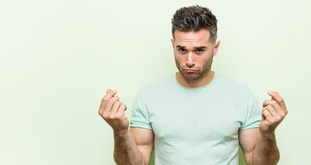 Young handsome man against a green background showing that she has no money.