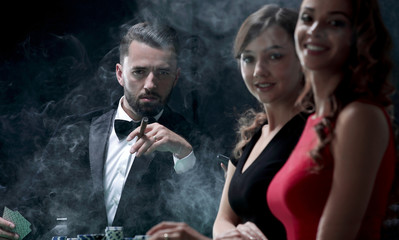 Upper class friends gambling in a casino.