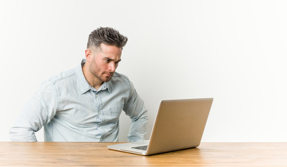 Young handsome man working with his laptop confident keeping hands on hips.