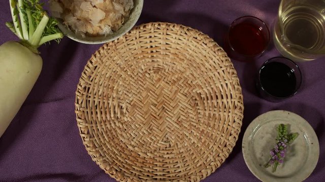 a Japanese female chef picking up ginger and grater from her kitchen table, Tokyo, Japan. July 2019. Camera fixed, close up, bird's eye view