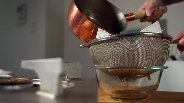 Japanese female chef filtering KATSUOBUSHI (bonito flakes) at her home kitchen, Tokyo, Japan. July 2019. Camera fixed, close up, neutral view,