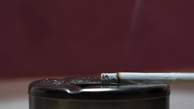 Cigarette burning in ash tray retro vintage