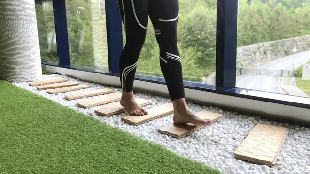 Crop woman walking on boards in gym