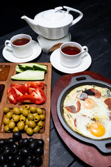 Varied, full Breakfast for two on the wooden table. 