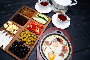Varied, full Breakfast for two on the wooden table. 