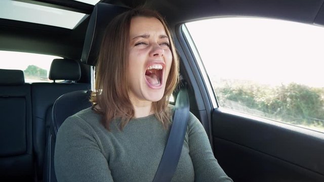 Woman in car screaming for desperation while driving scared