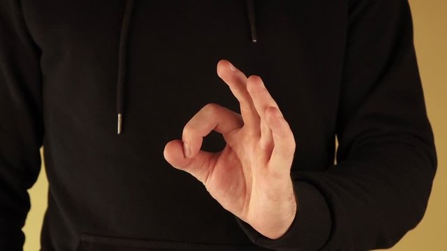 the man makes a gesture with his hand, meaning that everything is OK