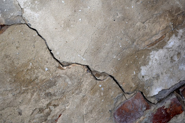Texture of gray old concrete wall with a large textured crack