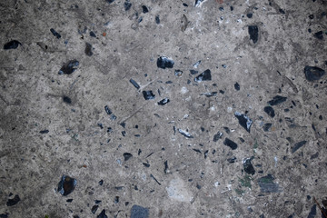 Texture of old grey concrete wall with black stones