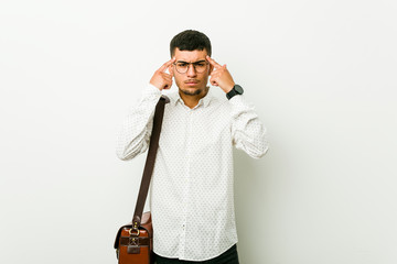 Young hispanic casual business man focused on a task, keeping forefingers pointing head.