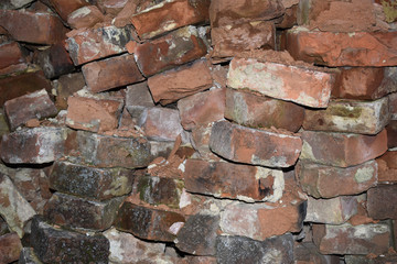 Фон, старая заваленная стена из разбитого красного кирпича.