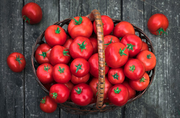 .basket with tomatoes on a wooden background