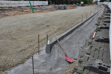 Der Straßenbau: eine neue Staße mit Bürgersteig entsteht. Auf der großen Baustelle werden mit...