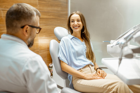 Young Patient With Senior Dentist During A Medical Consultation At The Dental Office