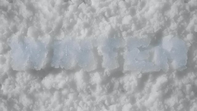 Letters made of ice melt in snow, timelapse. Background. Concept end of winter and beginning of spring. Christmas and New years eve. Cold weather gives way to warm weather. Holidays and celebrations