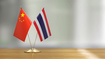 Chinese and Thai flag pair on a desk over defocused background  - 297861188