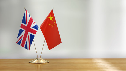 British and Chinese flag pair on a desk over defocused background  - 297861371