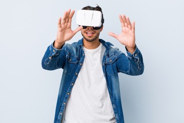 Young south-asian man playing with virtual reality glasses
