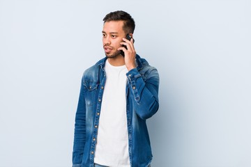 Young south-asian man holding a phone