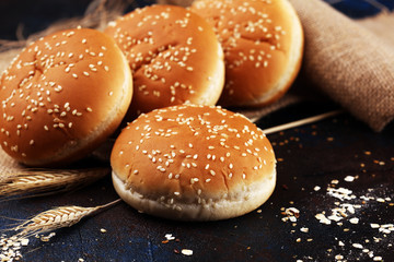 Fresh homemade burger buns with sesame on dark background
