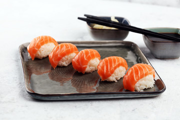 close up of sashimi sushi set with chopsticks and soy - sushi roll with salmon and sushi roll with smoked eel