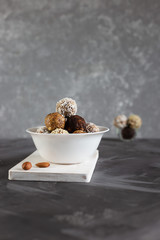 Energy protein balls on a gray table. Healthy, nutritious snack. Vertical photo.