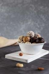 Energy protein balls on a gray table. Healthy, nutritious snack. Vertical photo.