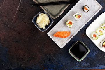 close up of sashimi sushi set with chopsticks and soy - sushi roll with salmon and sushi roll with smoked eel