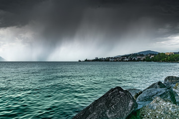 View of the city of Clarens on the shores of Lake Geneva and dark rainy clouds.Montreux,Switzerland.