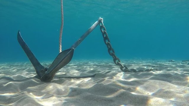 An anchor on the sandy bottom of the sea.