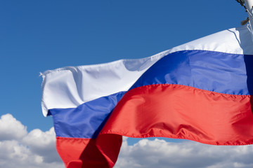 Naklejka na ściany i meble Russian flag waving in the wind, on a background blue sky