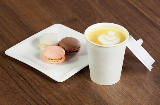 Paper cup with coffee and macaroons dessert on wooden table - Powered by Adobe