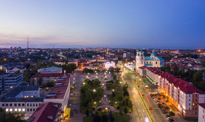 St. Francis Xavier Cathedral And Traffic In Mostowaja And Kirova Streets At Evening In Night Illuminations Lights. Sunset Sky. Grodno city in Belarus