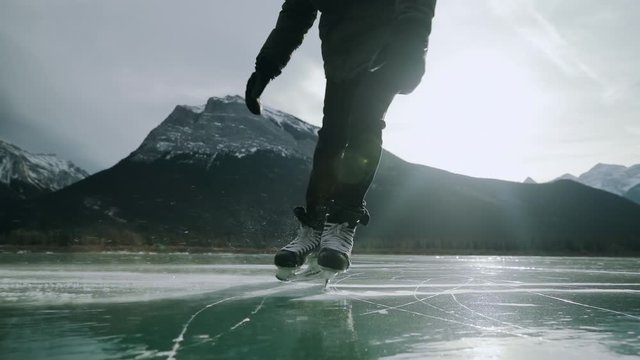 Low section of man skating on a frozen lake