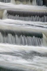 Fototapeta na wymiar River Meavy water flowing over graduated steps at Lopwell Weir, Plymouth, Devon