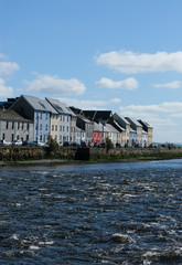 Famous view of the brightly painted houses of Galway city and the River Corrib rushing past on a sunny summer day