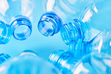 Set of empty water bottles lie isolated on blue background. Plastic production and processing concept