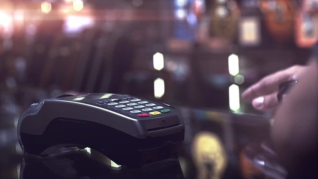 A man using smartwatch to purchase product at the point of sale terminal with near field communication identification technology to complete the transaction