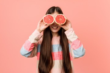 Young asian woman playing with a grapefruit